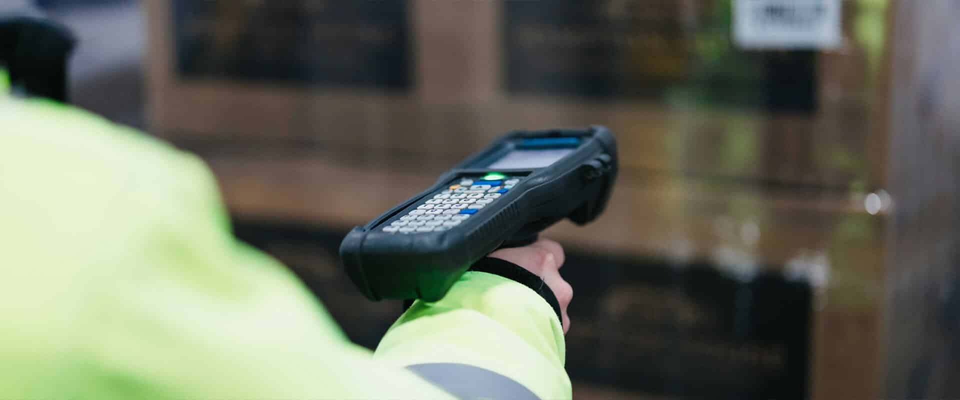 Warehouse worker holding and pointing a scanning device