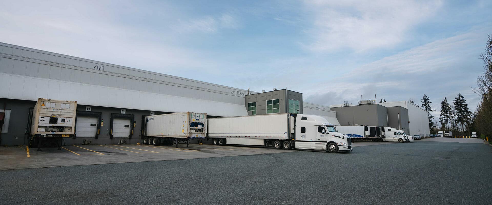 A transport truck unloading at a warehouse dock